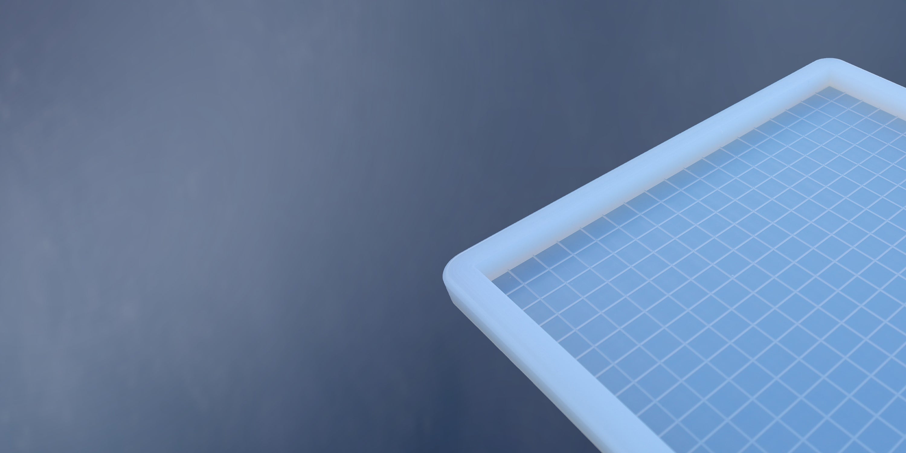 A white rectangular object with a blue grid surface is shown in the upper right corner against a plain blue background.