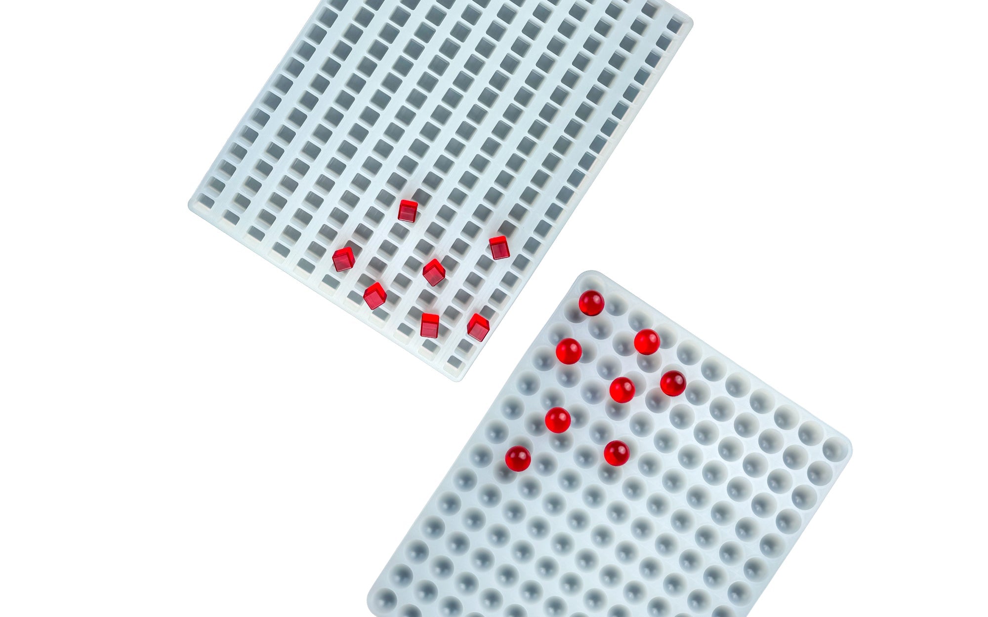 Red gummy bears are placed on top of a white silicone mold shaped like gummy bears, with a gray background.