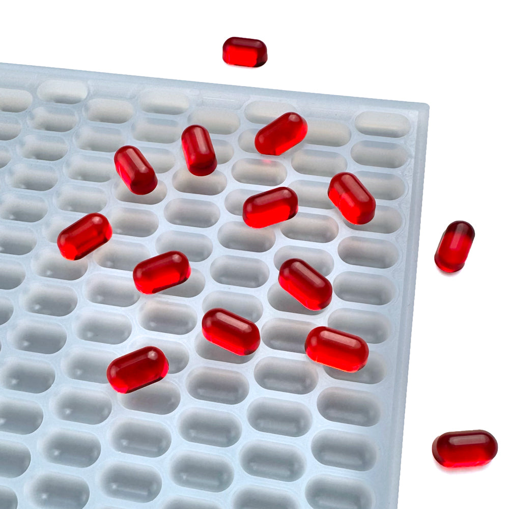 Custom food-grade silicone Capsule gummy mold, 0.5ml capsule-shaped cavities, shown with red gummies, compatible for flood and scrape