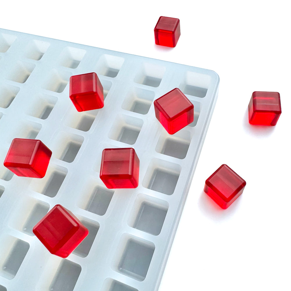 Red gelatin cubes are on and around the Vector Molds 2.8 mL Square Gummy Mold for Baker Perkins Depositor (231 cavities), made from platinum-cured, professional food grade silicone, set against a white background.