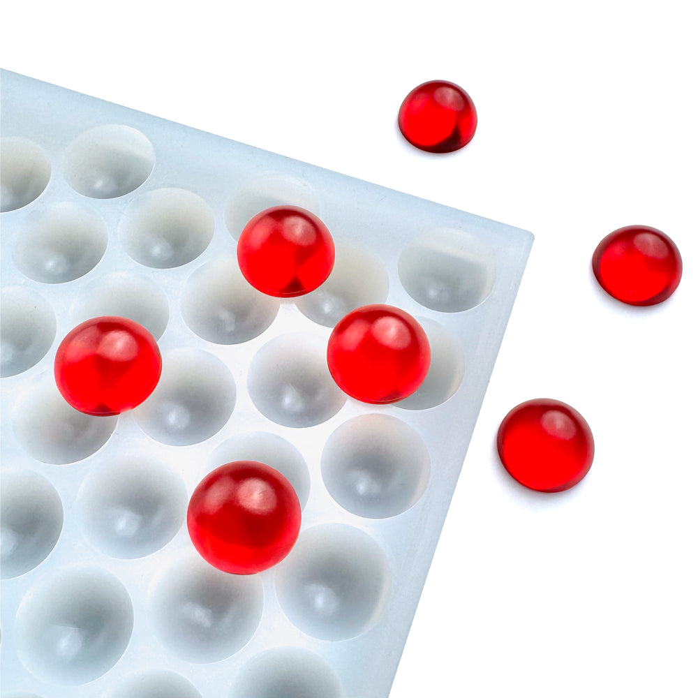 The Vector Molds 2 mL Bon Bon Gummy Mold - Sharp Half Sheet features 263 round cavities holding several translucent red gummies, with three gummies displayed outside the mold on a white background.