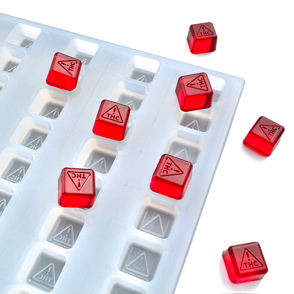 Food-grade silicone gummy mold, 2ml square cavities with NV & MS-compliant logo design, red gummies shown, universal depositor compatible.