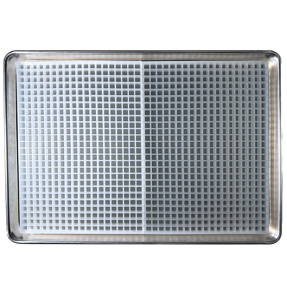 A metal baking sheet holds a Vector Molds 2 mL Cube Gummy Mold - Sharp Half Sheet with 494 small square cavities, made from professional food grade platinum silicone, viewed from above.