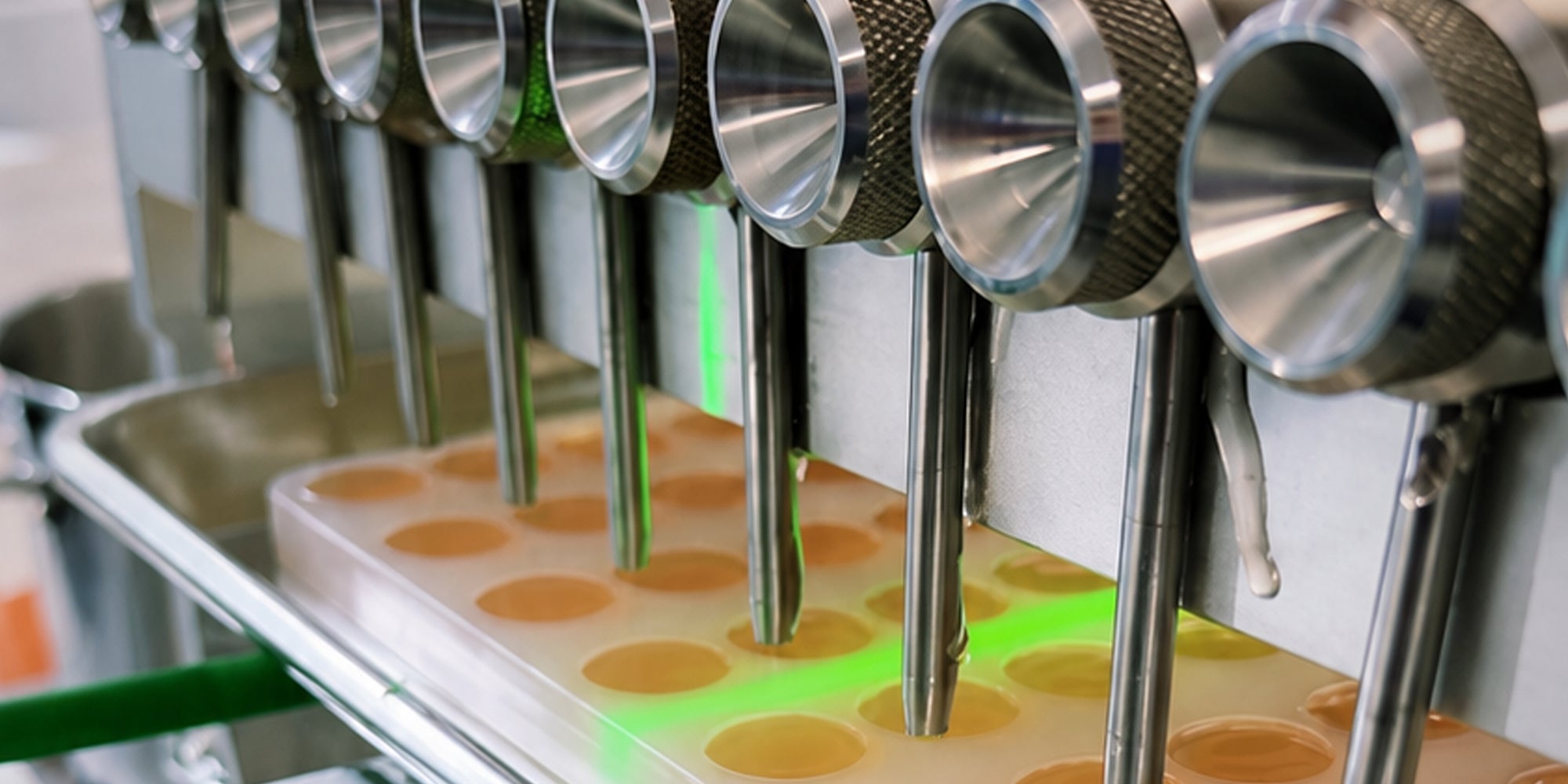 Custom-engineered 4-row industrial silicone candy mold optimized for dual-nozzle depositor dispensing on a high-speed automated commercial packaging line