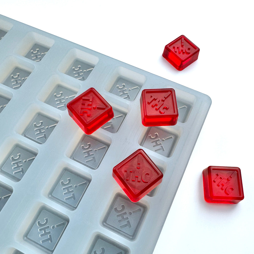 Custom food-grade silicone diamond-shaped gummy mold, 3ml cavities with state-compliant embossed symbols for CO, OH, NM, and FL, shown with red gummies, universal depositor compatible.